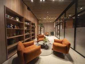 A modern interior with wooden bookshelves, orange sofas, and a central coffee table. - Loft-Style 1br Apt At coco del mar (Panamá)