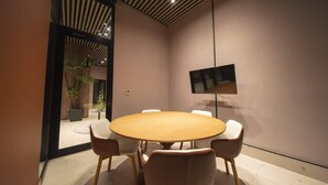 A conference room with a round table, four chairs, a flat-screen TV, and a potted plant. - Loft-Style 1br Apt At coco del mar (Panamá)