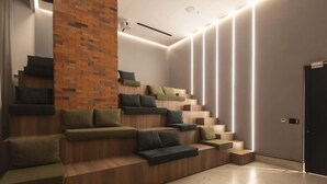 Eine moderne Treppe mit integrierten Sitzgelegenheiten, einer Ziegelwand als Akzent und eingelassener Beleuchtung.