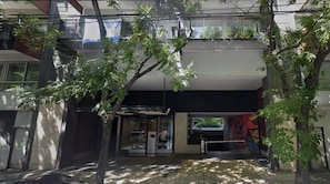 A modern building with a glass entrance, a balcony, and a tree in the foreground. - 1 Bedroom with balcony in Palermo Hollywood (Buenos Aires)