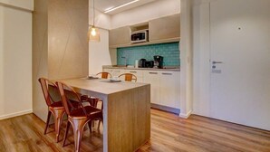 Eine moderne Küche mit einer zentralen Kochinsel, weißen Schränken und einer türkisblauen Spritzschutzwand.