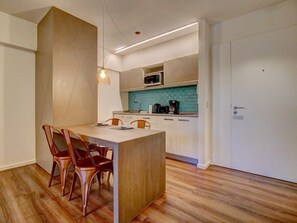 A modern kitchen with a central island, white cabinets, and a teal backsplash. - 1 Bedroom with balcony in Palermo Hollywood (Buenos Aires)