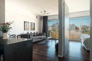 En moderne stue med sofa, sofabord og et spiseområde med bord og stole.