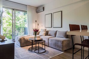 Ein modernes Wohnzimmer mit einer Couch, einem Couchtisch und einem Essbereich mit Stühlen.