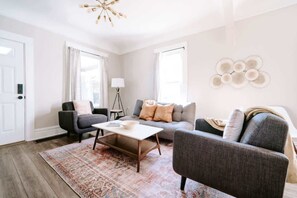 A modern living room with a sofa, armchairs, a coffee table, and a patterned rug. - Olde Town Ambler A Distinctive Walkable Retreat (Arvada)