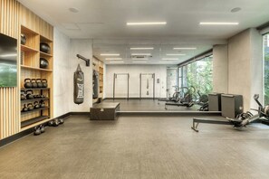 A gym with weightlifting equipment, a punching bag, and exercise bikes. - Chic Central Park Studio (Ciudad de México)