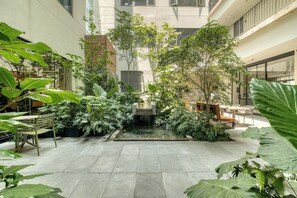 A courtyard with a water feature, seating, and lush greenery. - Chic Central Park Studio (Ciudad de México)
