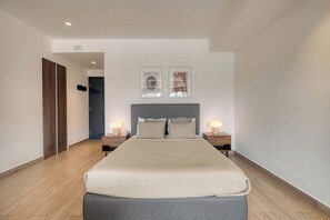A modern bedroom with a large bed, two bedside tables with lamps, a wardrobe, and two framed artworks on the wall. - Chic Central Park Studio (Ciudad de México)