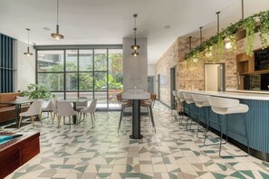 A modern cafe with a bar area, seating, and large windows. - Chic Central Park Studio (Ciudad de México)