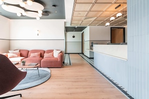 A modern interior with a sofa, a round coffee table, and a reception desk. - Apex Executive Apartments -  Lower Kilmacud (Dublin)