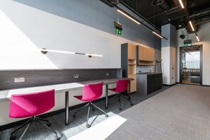 A modern office space with a long table, red chairs, a reception desk, and a visible exit door. - Apex Executive Apartments -  Lower Kilmacud (Dublin)