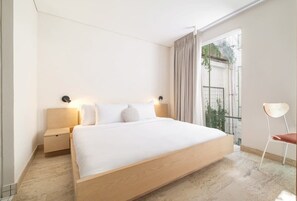 A modern hotel room with a large bed, bedside tables, and a chair. - CAM 1-Bdrm w Balcony (Ciudad de México)