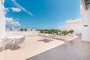 Eine Dachterrasse mit Sitzgelegenheiten im Freien und freiem Blick zum Himmel.