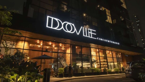 Un edificio con un letrero iluminado grande que dice 'DOVIE CINCUENTENARIO'.