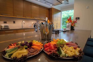 Cozinha moderna com armários de madeira, bancada de aço inoxidável e vista para o verde lá fora.