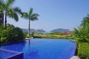 An infinity pool with a clear view of the sea and hills in the background. - Vista Bahia 1F - 1 bdr 1 bath Ocean View (Herradura)