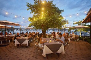 An outdoor dining area with tables and chairs, string lights, and umbrellas. - Montebello 1E 3 bed 3 bath, ocean view (Playa Herradura)