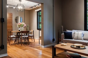 Ein modernes Wohnzimmer mit einem Holzesstisch, einer Couch und einem Couchtisch.