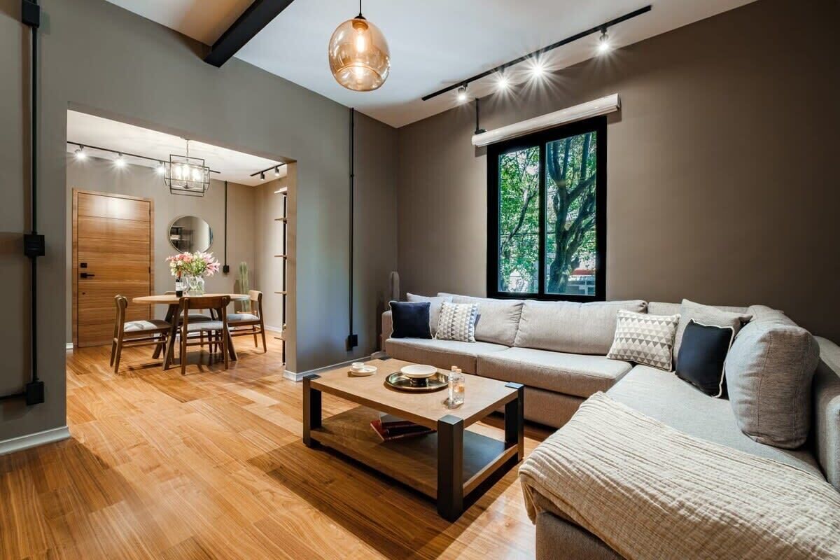 Una sala moderna con sofá, una mesa de centro y comedor.