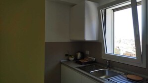 A compact kitchen with a window, a sink, and a countertop.