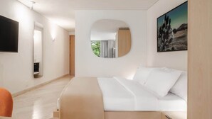 A modern hotel room with a bed, a round mirror, a painting, and a television. - Modern Loft with Balcony & View of Parque Mexico (Ciudad de México)