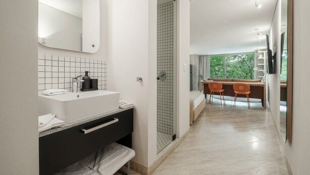 Ein modernes Badezimmer mit Waschbecken, Spiegel und Dusche.