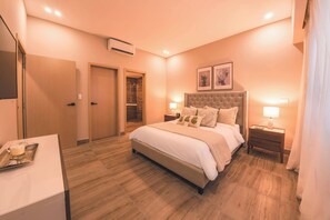 A bedroom with a large bed, bedside tables, a desk, and a wardrobe. - Modern flat for 3 in Piantini Gym & pool access (Santo Domingo)