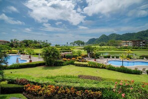 A resort with multiple swimming pools, lush gardens, and a view of the sea. - Del Mar 3i - 3 bdr 2 bath Ocean View (Playa Herradura)