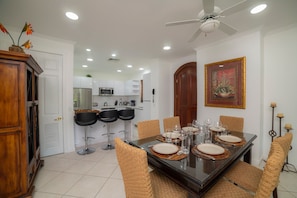 A dining area with a dark wooden table, woven chairs, and a ceiling fan. - Colina 5D -  3 bdr 2 bath Family (Playa Herradura)