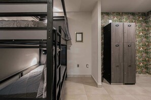 Ein Schlafzimmer mit Etagenbetten, einem Kleiderschrank und einem gerahmten Bild an der Wand.