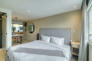 A modern hotel room with a large bed, a bedside table, a desk, and a view of the outside. - Modern King Studio in Central Roma Norte (Ciudad de México)