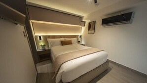 Una camera d'albergo moderna con un letto grande, comodini, condizionatore d'aria a parete e una lampada da comodino.