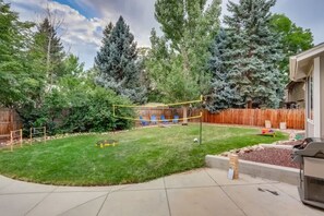 A backyard with a wooden fence, a trampoline, and a barbecue grill. - Hot Tub Modern Home Great Location (Arvada)