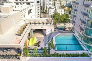 Ein Poolbereich auf dem Dach mit kleinem Pool, Sitzgelegenheiten im Freien und Topfpflanzen.