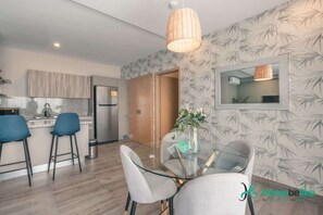 A modern kitchen with a bar area, a dining table with chairs, and a large mirror on the wall. - Regatta Living Ii with Breakfast Included! - 705 (Santo Domingo)