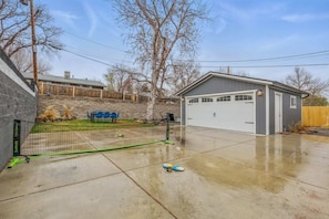 A residential garage with a covered driveway, a tennis court, and a small shed. - Projector Nights & Park Delights I Designer Reno (Arvada)