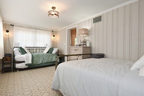 A bedroom with two beds, a bedside table, a lamp, and a mirror. - The Bulldog Farmhouse - 100+ year old home (Athens)