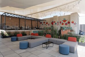 An outdoor seating area with sofas and tables, string lights, and a mural with heart designs. - Serviced Studio in Mexico City (Ciudad de México)