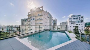 A rooftop swimming pool with a clear view of surrounding high-rise buildings. - Flat in Regatta Ii with breakfast included 304 (Santo Domingo)