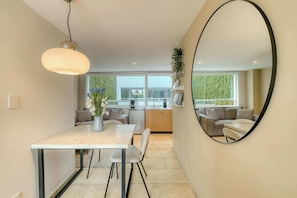 A modern kitchen with a dining area, a large mirror, and a view of the outdoors. - Modern King Studio in Central Roma Norte (Ciudad de México)