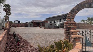 A residential area with RVs, a patio, and cacti. - A GREAT PRICE! FOR A COZY CASITA, SECURED ON A LARGE PRIVATE LOT ALL TO YOURSELF (Yuma)