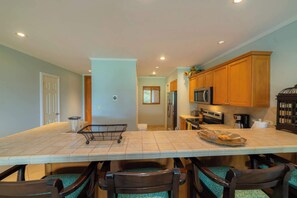Cocina con una isla grande, armarios de madera y electrodomésticos modernos.