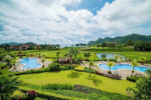 Ein Resort mit zwei Swimmingpools, üppiger Vegetation und einem Golfplatz.