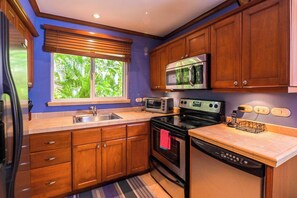 A kitchen with wooden cabinets, a microwave, a toaster, and a dishwasher. - Veranda 1H -  3 bdr 3 bath Family (Playa Herradura)