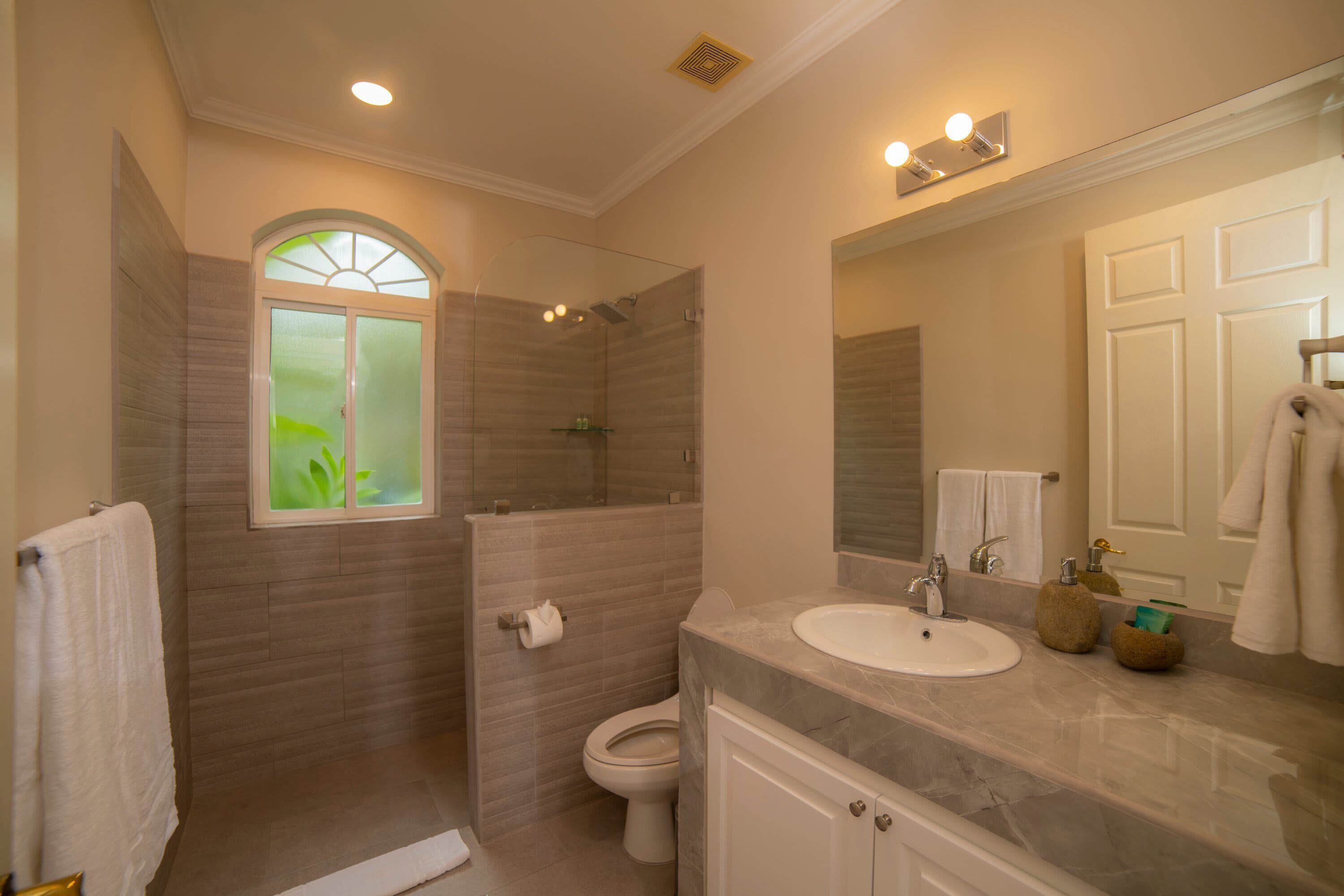 Un baño con ducha, inodoro y lavabo.