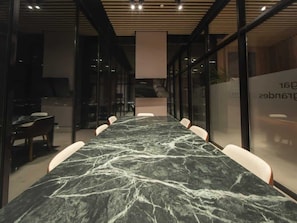 A conference room with a marble table and chairs, glass walls, and a modern ceiling design. - City Loft Duplex near to restaurant (Panamá)