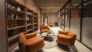 A modern interior with wooden bookshelves, orange sofas, and a central coffee table. - Feel like home in spacious 1br apartment (Panamá)