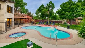 Zona de piscina con dos jacuzzis, sillas de descanso y una terraza cubierta.