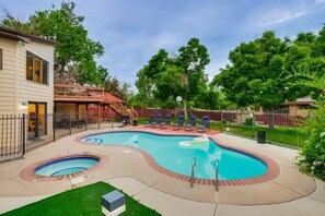 Ein Poolbereich mit zwei Whirlpools, Liegestühlen und einer überdachten Terrasse.