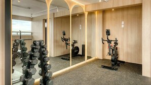 A gym with exercise equipment, mirrors, and a view of the outside. - Modern King Studio in Central Roma Norte (Ciudad de México)